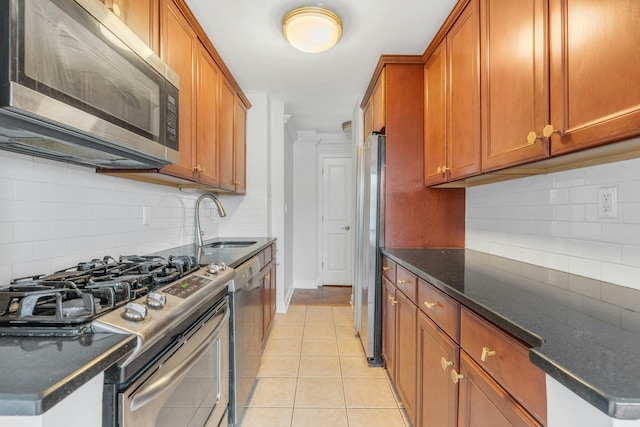 kitchen featuring stainless steel appliances, backsplash, sink, and light tile patterned floors