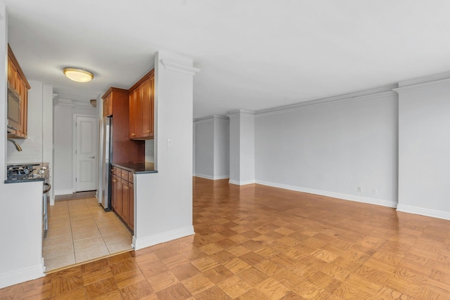 kitchen with appliances with stainless steel finishes, crown molding, and light parquet flooring