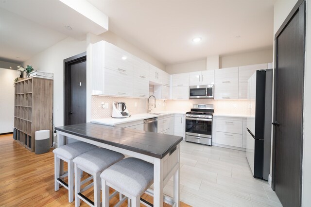 65 Storms Ave Unit 2C, Jersey City, NJ 07306 - kitchen featuring stainless steel appliances, tasteful backsplash, a sink, modern cabinets, and recessed lighting