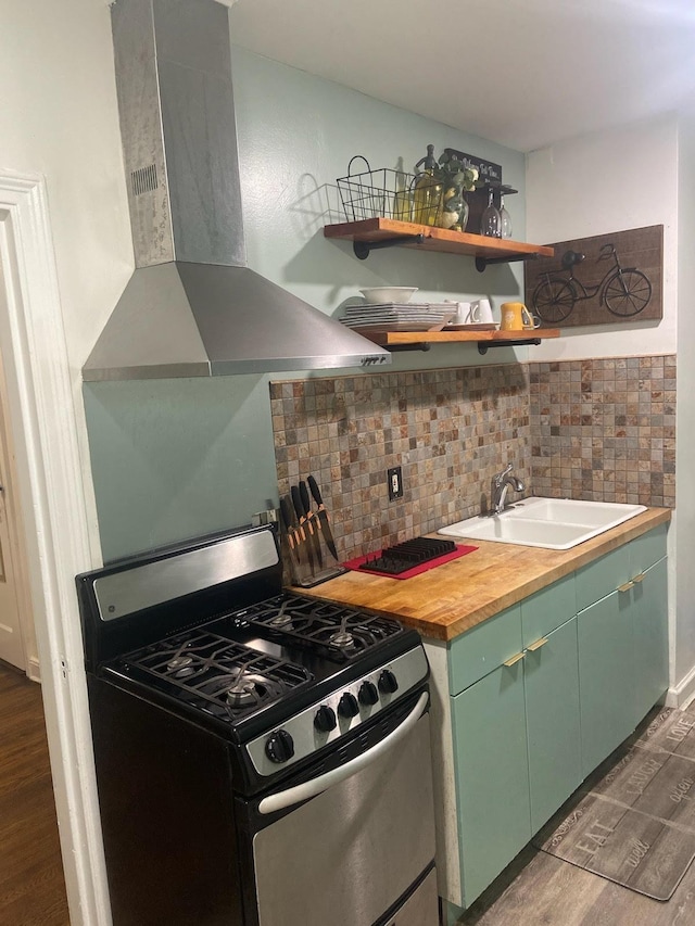 kitchen with backsplash, sink, gas range, dark hardwood / wood-style floors, and extractor fan