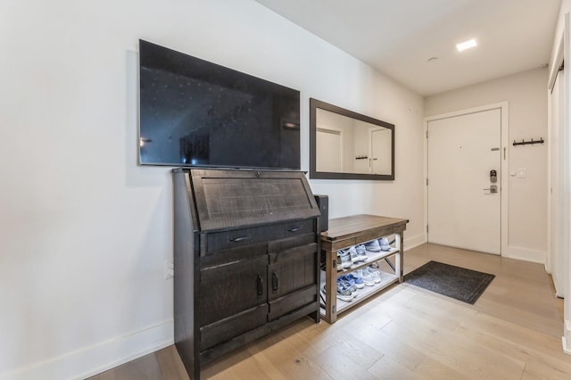 foyer featuring baseboards and wood finished floors