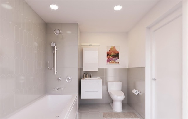 bathroom featuring toilet, tile walls, tile patterned flooring, bathing tub / shower combination, and vanity