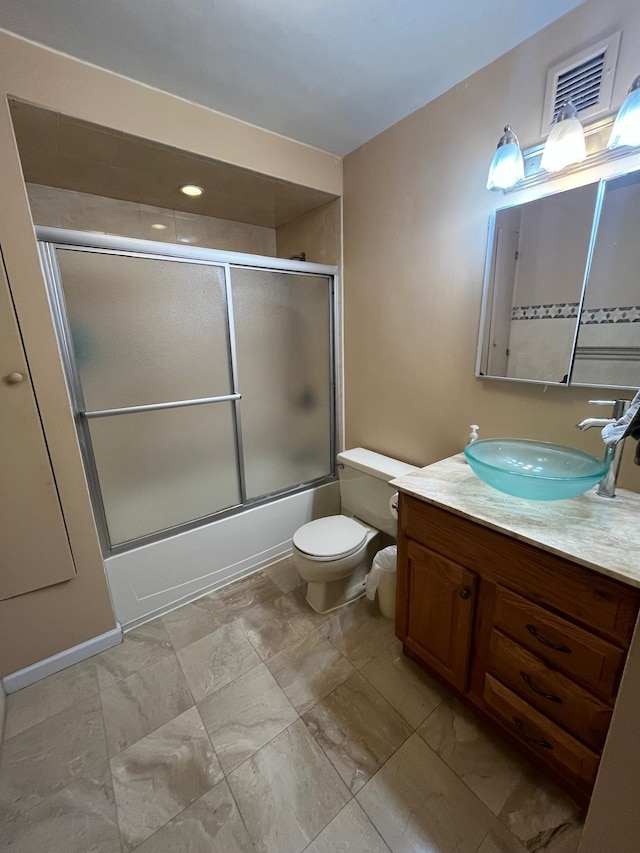 full bathroom featuring shower / bath combination with glass door, toilet, and vanity