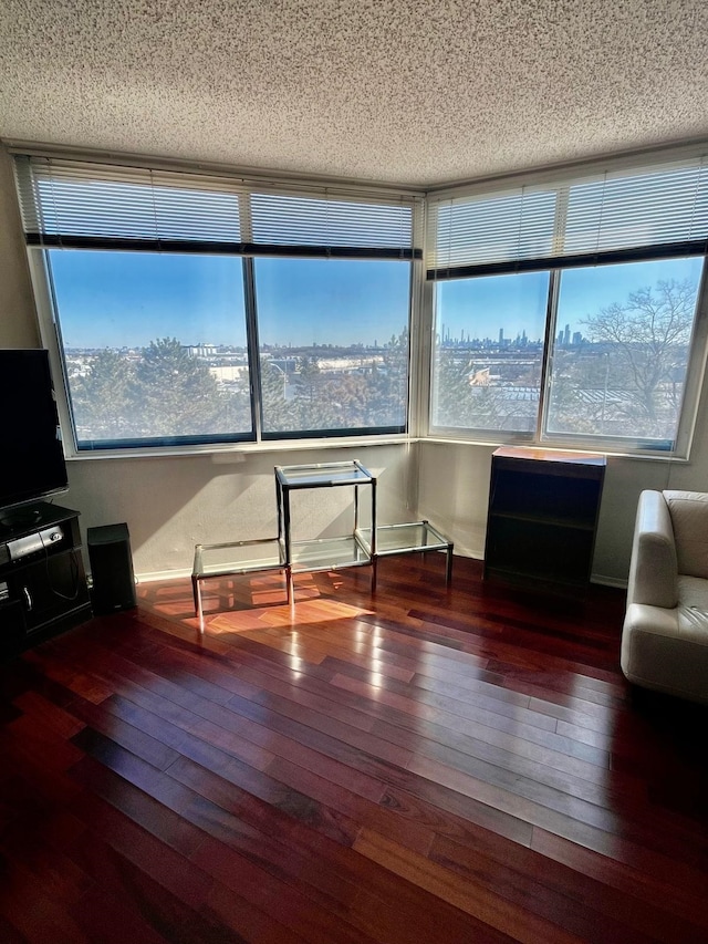 unfurnished living room featuring hardwood / wood-style floors and a textured ceiling