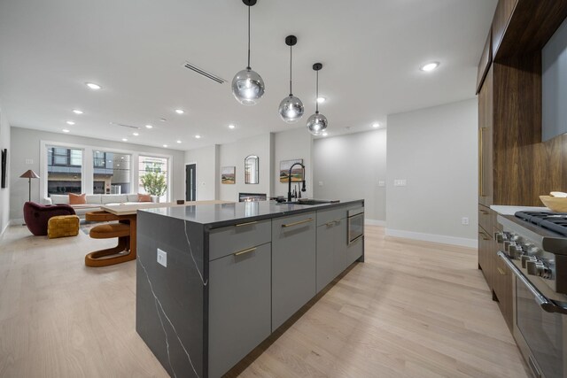 45 Graham St Unit 1, Jersey City, NJ 07307 - kitchen with high end stainless steel range oven, modern cabinets, a kitchen island with sink, light wood finished floors, and recessed lighting