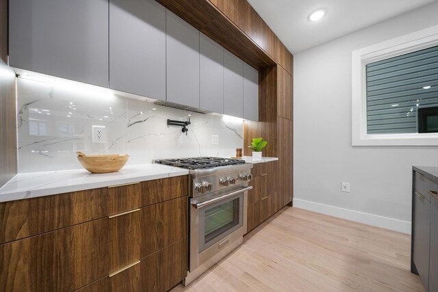 45 Graham St Unit 1, Jersey City, NJ 07307 - kitchen featuring high end range, modern cabinets, light wood-type flooring, decorative backsplash, and recessed lighting