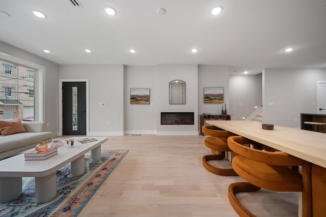 45 Graham St Unit 1, Jersey City, NJ 07307 - living area featuring stairs, light wood finished floors, recessed lighting, and a glass covered fireplace