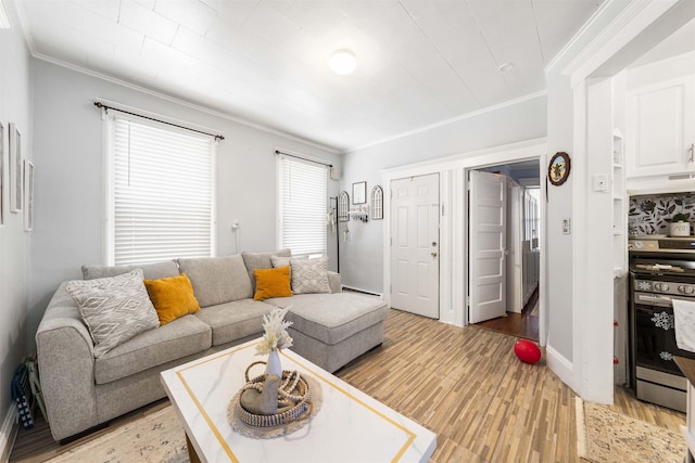 living room with crown molding, light wood-type flooring, and baseboards