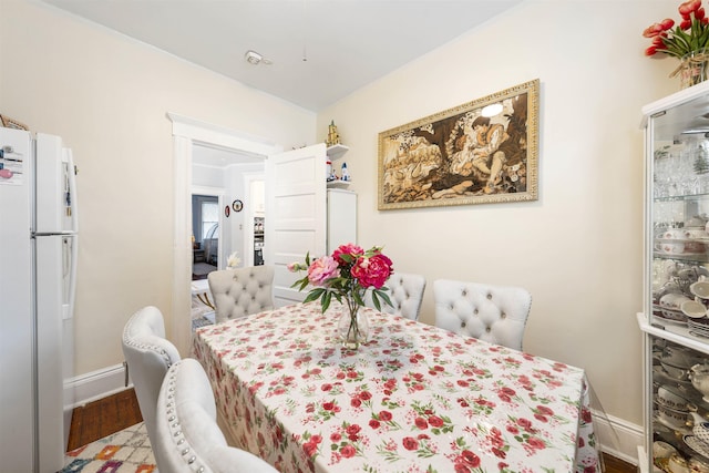 dining space with baseboards and wood finished floors