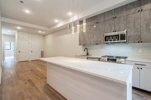 545 Palisade Ave Unit 2, Jersey City, NJ 07307 - kitchen featuring stainless steel appliances, a sink, decorative backsplash, wood finished floors, and recessed lighting