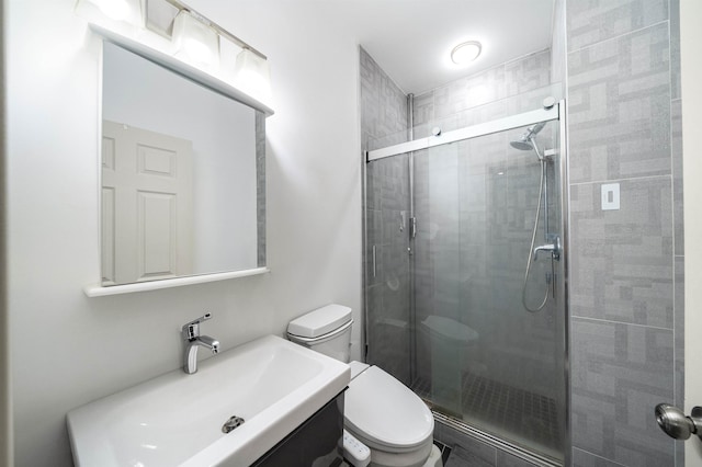 bathroom with walk in shower, vanity, and toilet