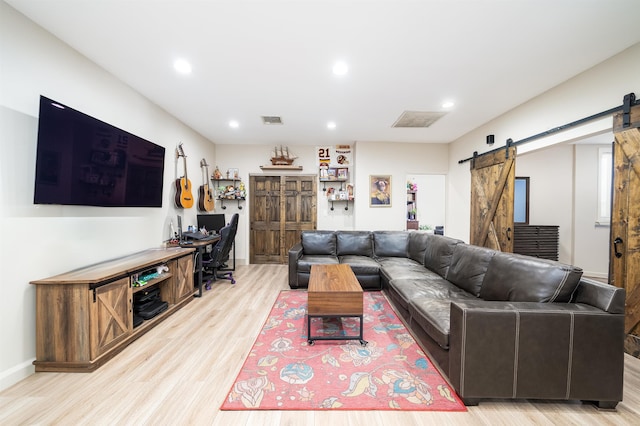 living room featuring light wood-type flooring and a barn door