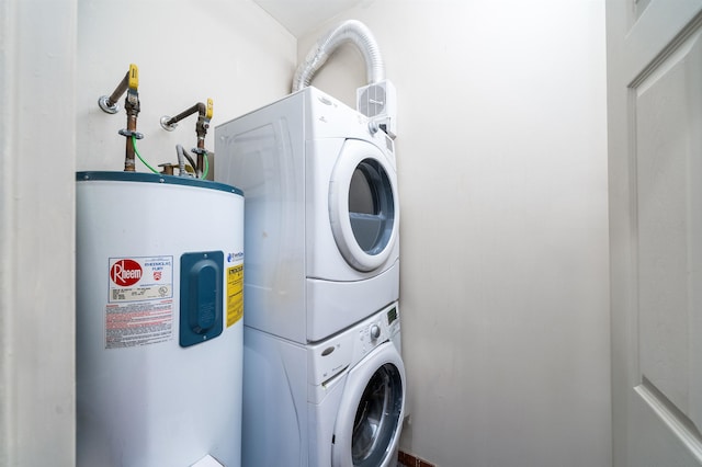 clothes washing area with electric water heater and stacked washer and clothes dryer