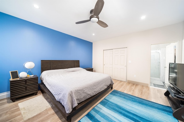 bedroom featuring connected bathroom, a closet, hardwood / wood-style floors, and ceiling fan