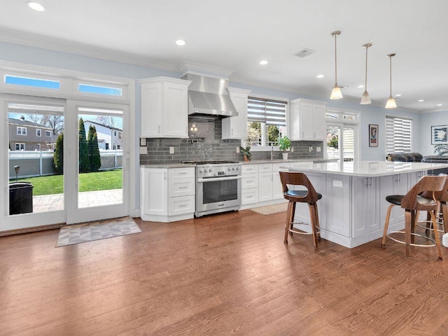 183 Oak Ave, River Edge, NJ 07661 - kitchen featuring high end range, wall chimney exhaust hood, wood finished floors, white cabinets, and recessed lighting