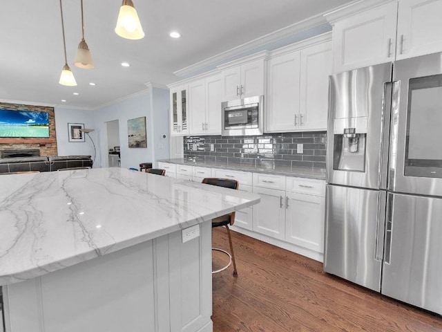 183 Oak Ave, River Edge, NJ 07661 - kitchen featuring appliances with stainless steel finishes, ornamental molding, dark wood finished floors, white cabinets, and backsplash