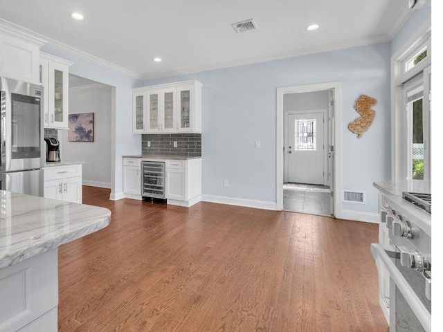 183 Oak Ave, River Edge, NJ 07661 - kitchen featuring beverage cooler, stainless steel appliances, baseboards, white cabinets, and ornamental molding