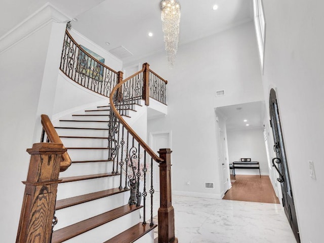 183 Oak Ave, River Edge, NJ 07661 - stairs featuring marble tiled floors, a chandelier, a high ceiling, recessed lighting, and baseboards