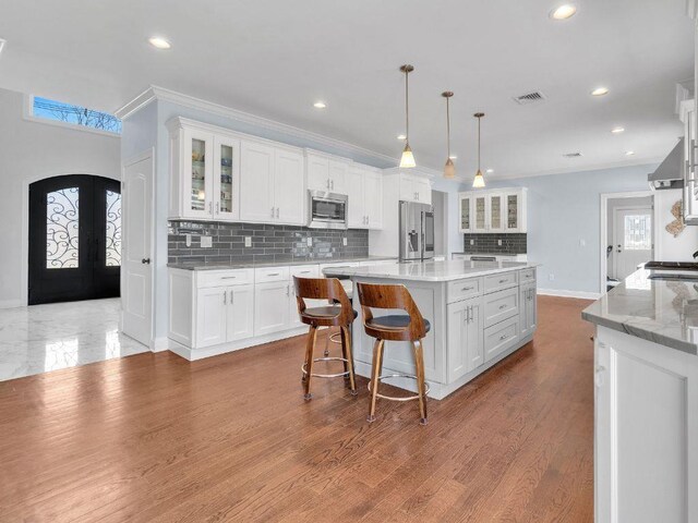 183 Oak Ave, River Edge, NJ 07661 - kitchen with appliances with stainless steel finishes, french doors, recessed lighting, white cabinets, and tasteful backsplash