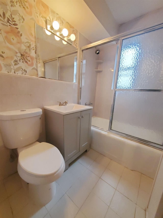 full bathroom featuring tile patterned flooring, bath / shower combo with glass door, tile walls, and toilet