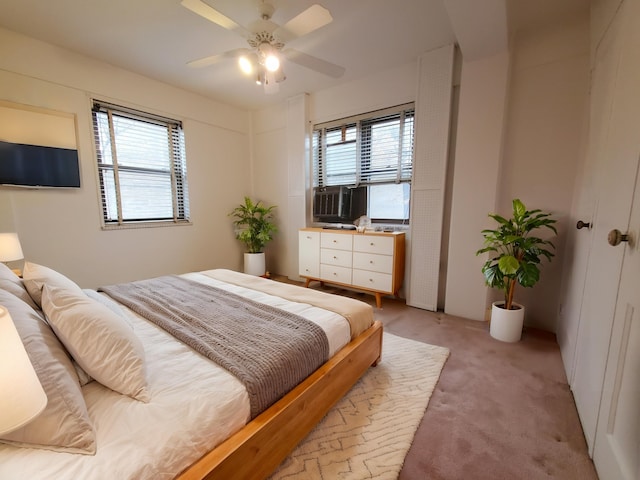 carpeted bedroom featuring multiple windows and ceiling fan