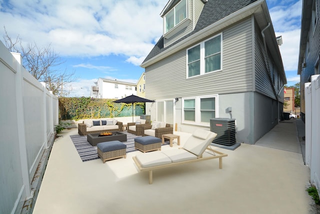 view of patio / terrace with central AC unit, a fenced backyard, and an outdoor living space with a fire pit