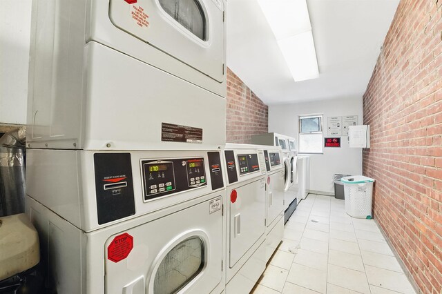 2520 Kennedy Blvd Unit 4J, Jersey City, NJ 07304 - shared laundry room featuring brick wall, estacked washer and dryer, light tile patterned floors, and washing machine and clothes dryer