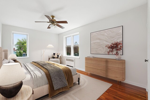 2520 Kennedy Blvd Unit 4J, Jersey City, NJ 07304 - bedroom with radiator, multiple windows, dark wood-style floors, and a ceiling fan