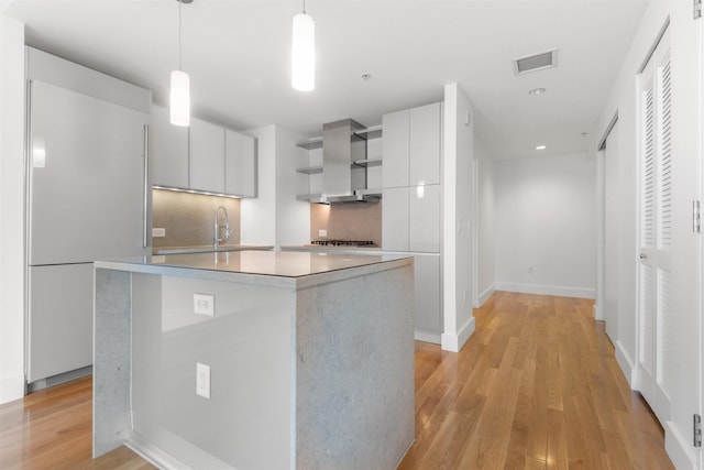 77 Hudson St Unit 1712, Jersey City, NJ 07302 - kitchen with modern cabinets, high end refrigerator, island range hood, white cabinets, and light countertops