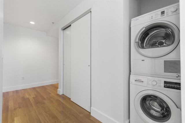 77 Hudson St Unit 1712, Jersey City, NJ 07302 - laundry room featuring stacked washer / dryer, wood finished floors, recessed lighting, and baseboards