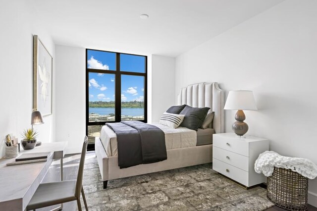 bedroom with expansive windows and a water view