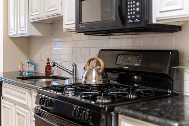 kitchen with backsplash, sink, white cabinets, and black appliances