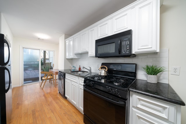 kitchen featuring white cabinets, backsplash, and black appliances