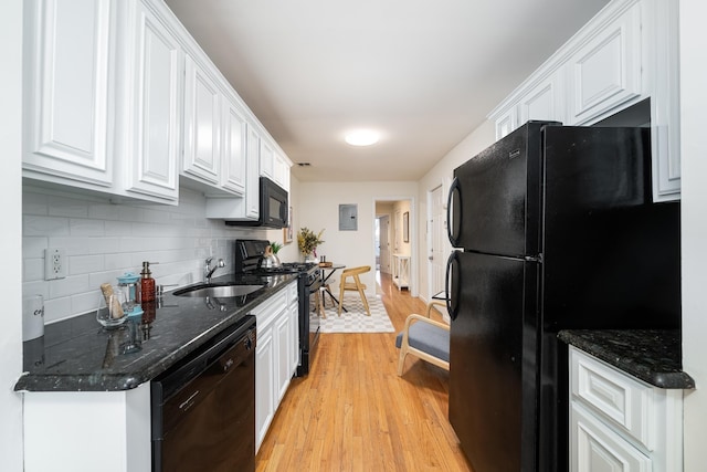 kitchen with sink, light hardwood / wood-style floors, decorative backsplash, white cabinets, and black appliances