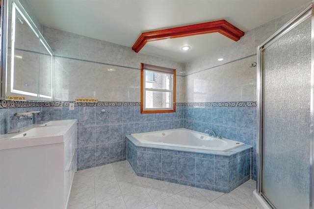 bathroom with tile walls, a bath, a stall shower, tile patterned flooring, and double vanity