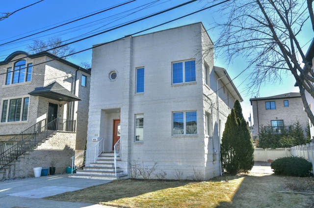 view of front of property featuring fence and brick siding
