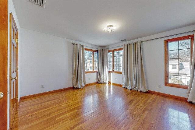empty room featuring light wood-style floors and baseboards