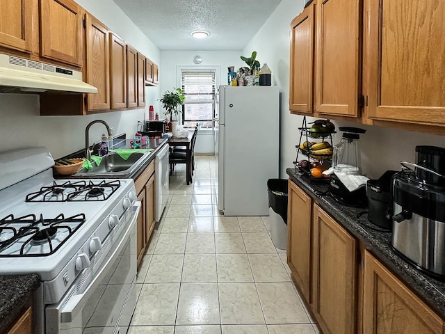 36 Duncan Ave Unit D2, Jersey City, NJ 07304 - kitchen featuring white appliances, under cabinet range hood, a sink, brown cabinets, and a textured ceiling
