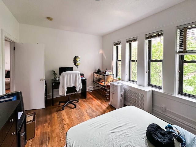 36 Duncan Ave Unit D2, Jersey City, NJ 07304 - bedroom featuring wood finished floors, radiator heating unit, and an office area