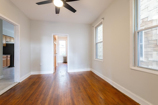 spare room featuring ceiling fan and dark hardwood / wood-style floors