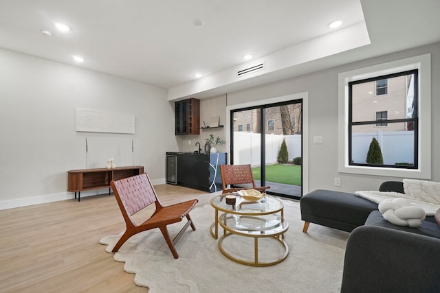 living room featuring light hardwood / wood-style floors and bar