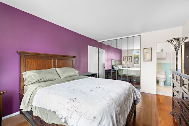 bedroom with wood-type flooring and ensuite bath