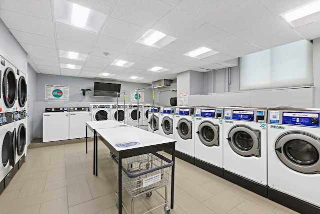 communal laundry room with independent washer and dryer, stacked washer / drying machine, and light flooring