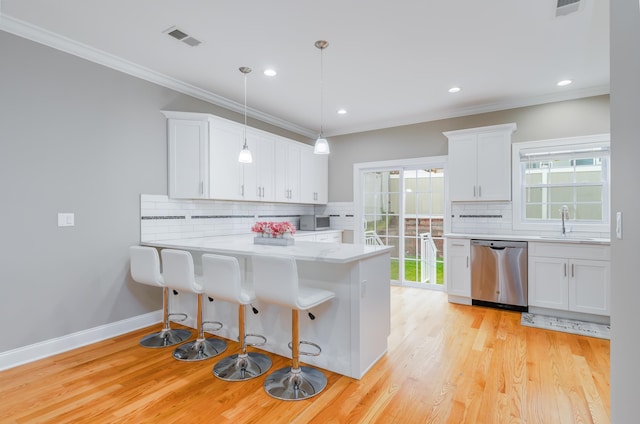 347 Forest St, Kearny, NJ 07032 - kitchen with stainless steel dishwasher, light countertops, tasteful backsplash, white cabinets, and healthy amount of natural light
