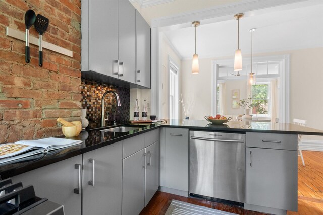112 Wayne St Unit 2-A, Jersey City, NJ 07302 - kitchen with stainless steel dishwasher, a peninsula, dark countertops, gray cabinetry, and crown molding
