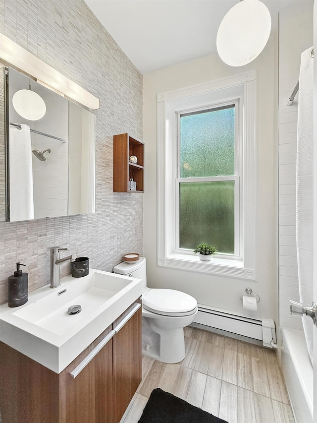 112 Wayne St Unit 2-A, Jersey City, NJ 07302 - bathroom featuring a baseboard radiator, vanity, tasteful backsplash, and shower / bath combo with shower curtain