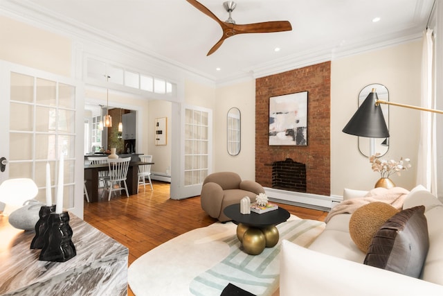 112 Wayne St Unit 2-A, Jersey City, NJ 07302 - living room featuring baseboard heating, hardwood / wood-style floors, crown molding, a ceiling fan, and a brick fireplace