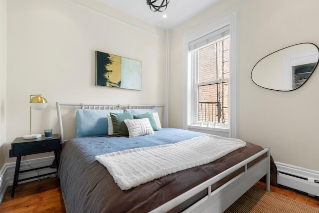 112 Wayne St Unit 2-A, Jersey City, NJ 07302 - bedroom with baseboard heating, wood finished floors, and recessed lighting