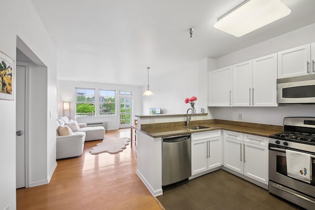30 Freedom Way Unit 306, Jersey City, NJ 07305 - kitchen featuring appliances with stainless steel finishes, a sink, a peninsula, white cabinets, and open floor plan