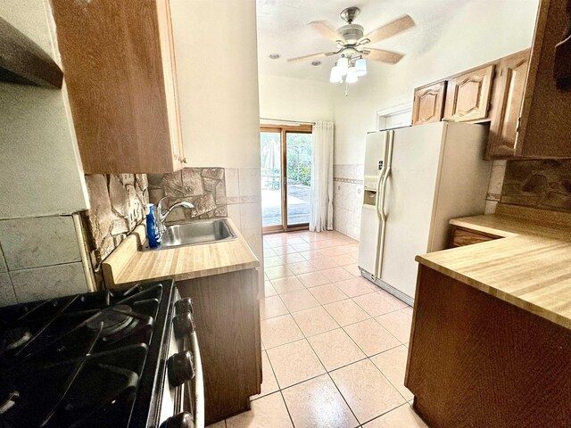 306 Columbia Ave, Jersey City, NJ 07307 - kitchen with gas range, white fridge with ice dispenser, ceiling fan, light tile patterned floors, and backsplash